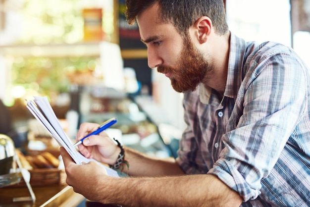 restaurant writing man with paperwork inventory menu items stock checklist by counter coffee shop small business person with documents planning budget review cafe products 590464 472927.jpg